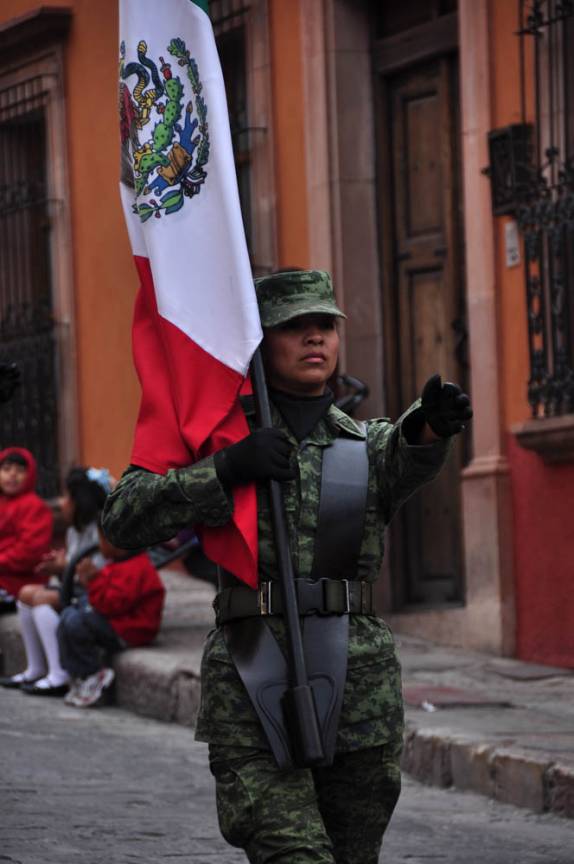 Carregando, com pompa e circunstância, a bandeira do país, durante desfile em San Miguel de Allende, no México